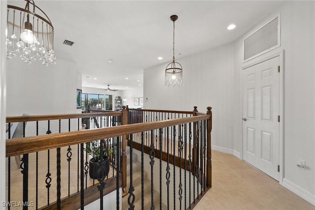 corridor featuring light tile patterned floors, recessed lighting, visible vents, and an inviting chandelier