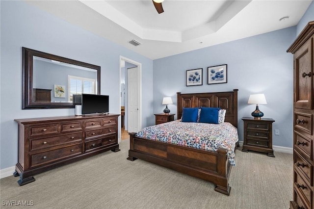 bedroom featuring ceiling fan, light carpet, visible vents, baseboards, and a raised ceiling