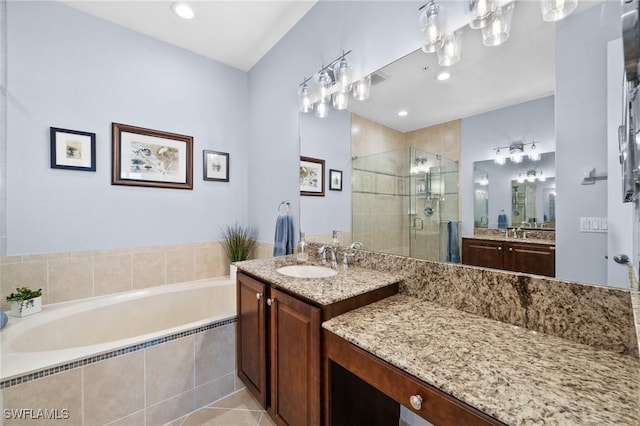 full bathroom with two vanities, a sink, a shower stall, and a bath