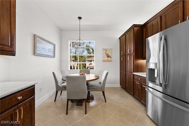 dining space featuring baseboards and light tile patterned floors