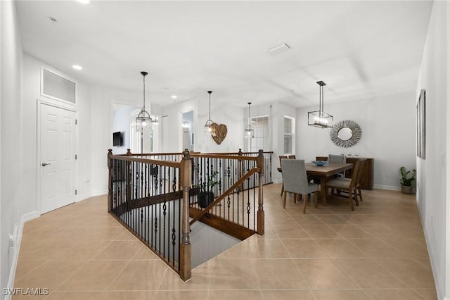 interior space featuring light tile patterned floors, recessed lighting, baseboards, and an inviting chandelier