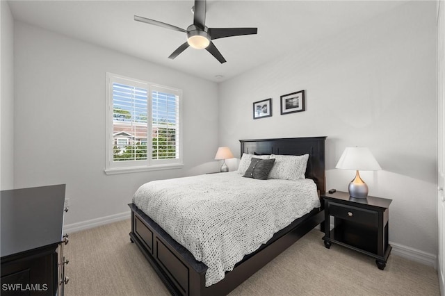 bedroom featuring light carpet, ceiling fan, and baseboards