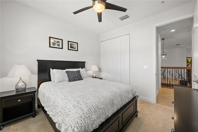 bedroom featuring baseboards, visible vents, light colored carpet, a closet, and ceiling fan with notable chandelier