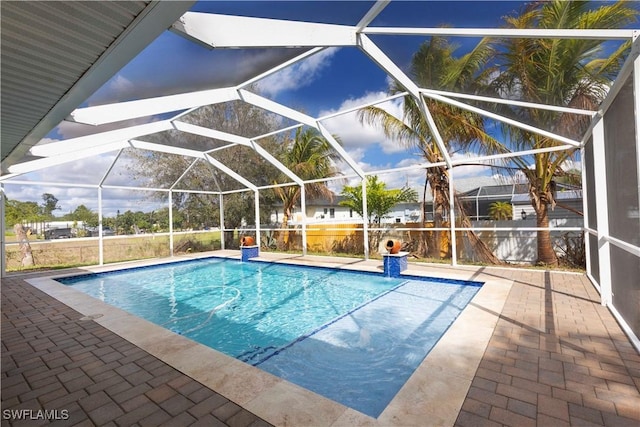 pool featuring glass enclosure and a patio area