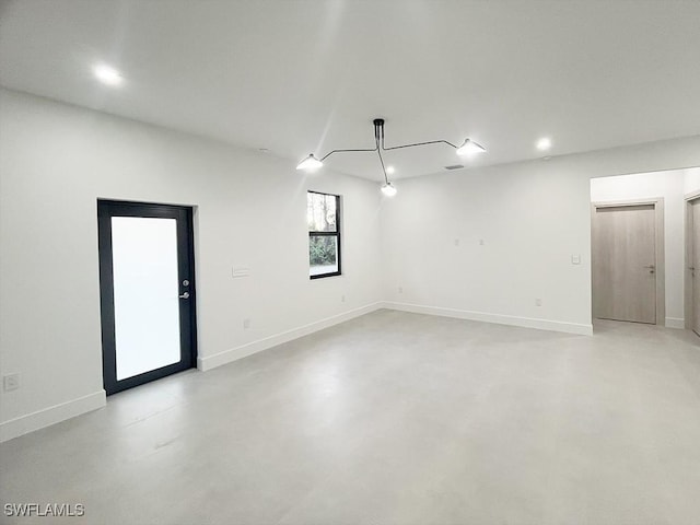 spare room with concrete flooring and baseboards