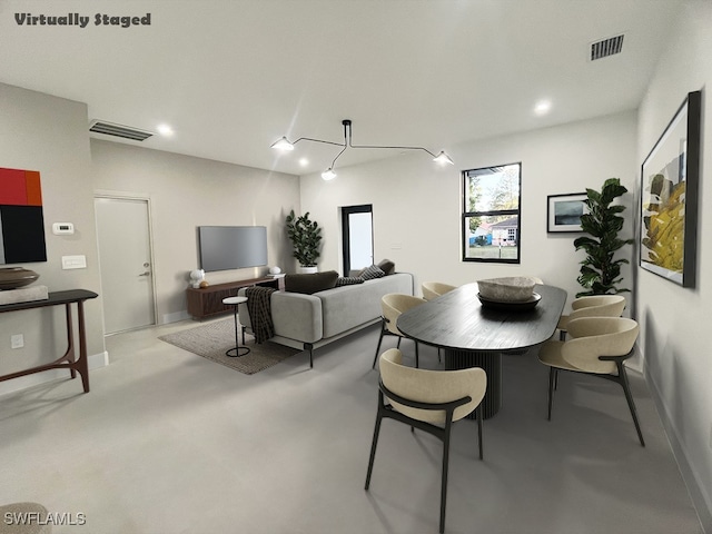 dining space featuring concrete floors, visible vents, and baseboards