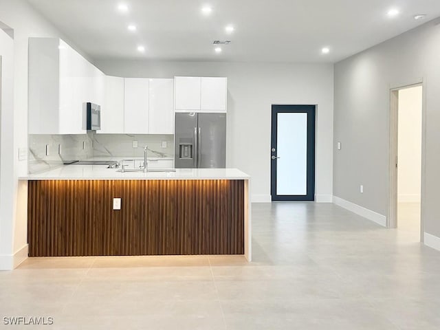 kitchen with tasteful backsplash, visible vents, appliances with stainless steel finishes, light countertops, and a sink