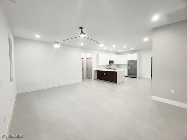 unfurnished living room featuring recessed lighting, visible vents, a sink, concrete flooring, and baseboards