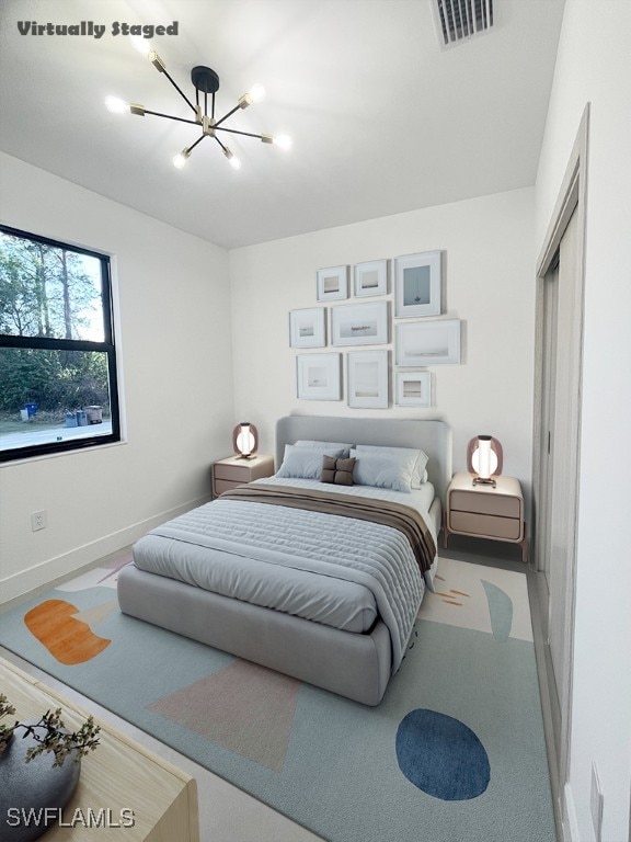 bedroom featuring baseboards, visible vents, and an inviting chandelier