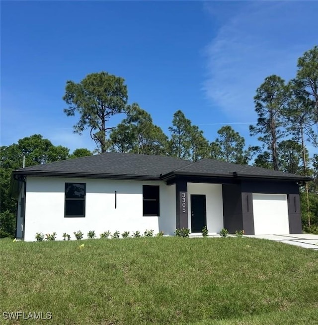 view of front facade with a front lawn, concrete driveway, an attached garage, and stucco siding