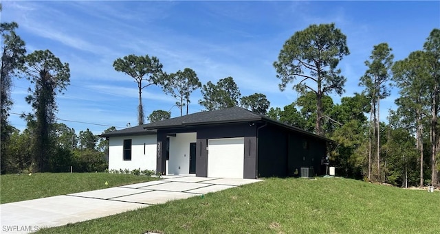 view of front of house featuring an attached garage, a front yard, cooling unit, and stucco siding