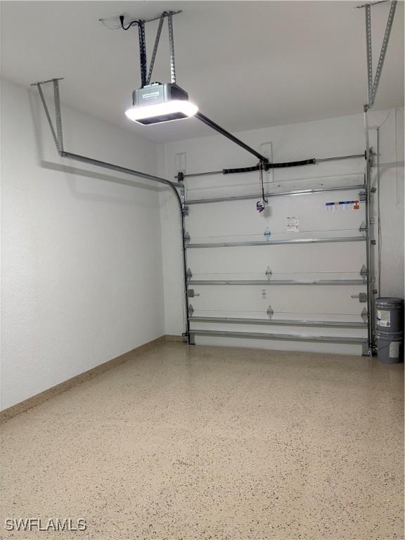 garage featuring a garage door opener and baseboards