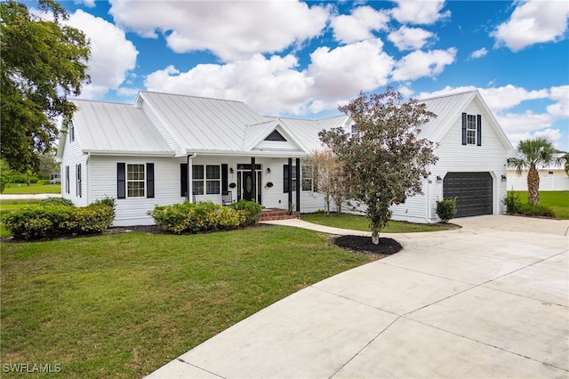 view of front of home with a porch, concrete driveway, metal roof, a garage, and a front lawn