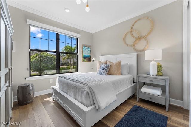 bedroom featuring crown molding, baseboards, and wood finished floors