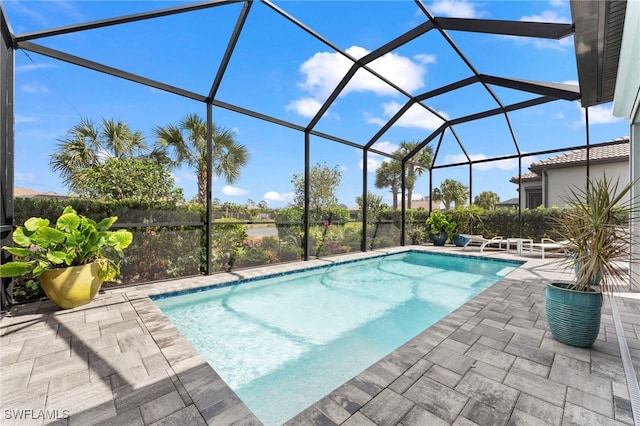 outdoor pool with glass enclosure and a patio area