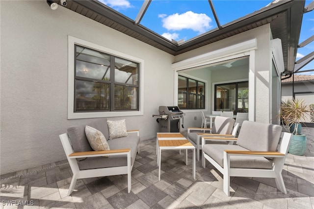 view of patio / terrace featuring glass enclosure, outdoor lounge area, and a grill