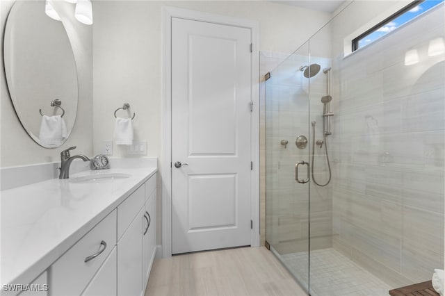 bathroom with a shower stall and vanity