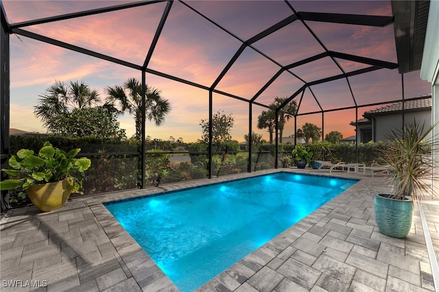 pool featuring glass enclosure and a patio