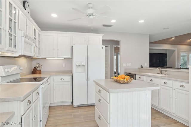 kitchen with light countertops, white appliances, and white cabinets