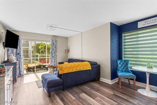 bedroom featuring access to outside, baseboards, and wood finished floors