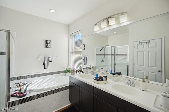 full bath featuring double vanity, a stall shower, a garden tub, and a sink