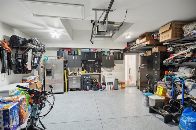 garage featuring a garage door opener and stainless steel fridge with ice dispenser