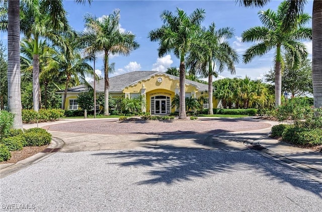 view of front of property featuring decorative driveway, french doors, and stucco siding