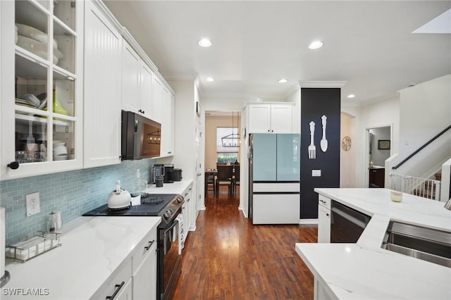 kitchen with dark wood finished floors, tasteful backsplash, black electric range oven, freestanding refrigerator, and white cabinetry