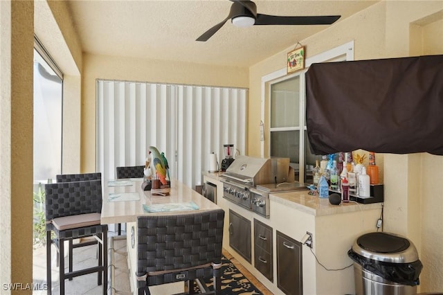 view of patio with a ceiling fan, grilling area, and an outdoor kitchen