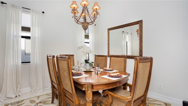 dining space with an inviting chandelier, plenty of natural light, and baseboards