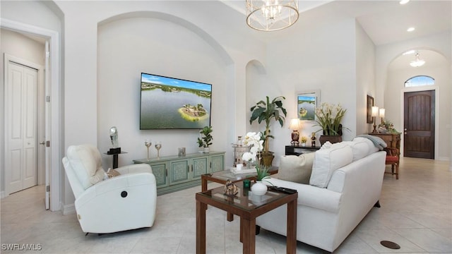 living room with arched walkways, light tile patterned floors, recessed lighting, and an inviting chandelier