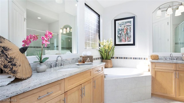 8342 Provencia Ct, Fort Myers, FL 33912 - bathroom featuring two vanities, a shower stall, a garden tub, and tile patterned flooring