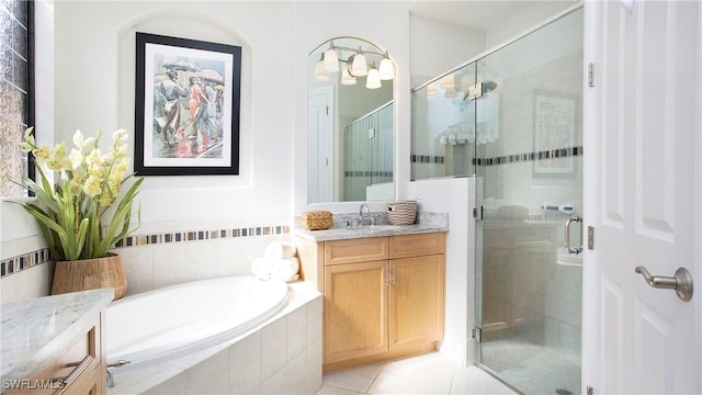 bathroom featuring a stall shower, tile patterned floors, vanity, and a bath