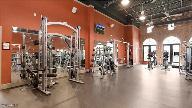 gym featuring brick wall and a towering ceiling