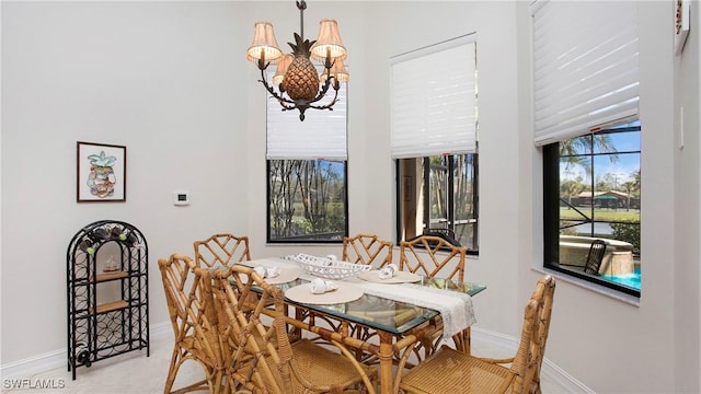 dining space featuring a chandelier and baseboards