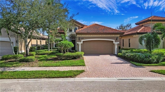 8342 Provencia Ct, Fort Myers, FL 33912 - mediterranean / spanish-style home with a garage, decorative driveway, stucco siding, and a tiled roof
