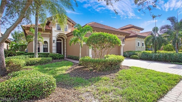 8342 Provencia Ct, Fort Myers, FL 33912 - mediterranean / spanish home with stucco siding, concrete driveway, an attached garage, and a tiled roof