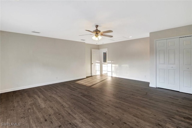 interior space featuring dark wood-style floors, a closet, visible vents, and baseboards