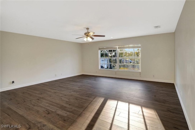 unfurnished room featuring dark wood-style floors, visible vents, baseboards, and a ceiling fan