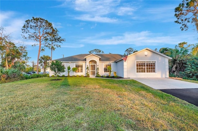 ranch-style home with a garage, driveway, a front lawn, and stucco siding