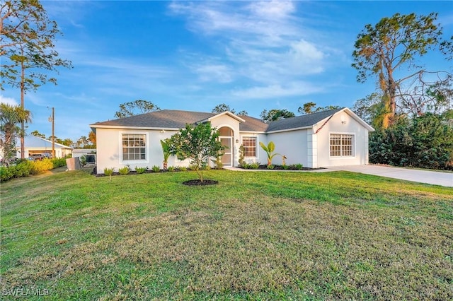 ranch-style home with a front lawn and stucco siding