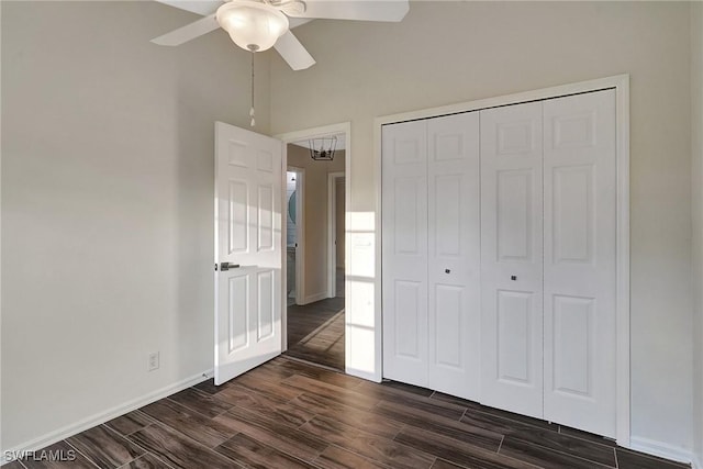 unfurnished bedroom featuring baseboards, ceiling fan, a closet, and wood tiled floor