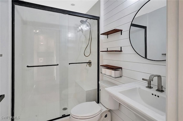 bathroom with toilet, a stall shower, wooden walls, and a sink