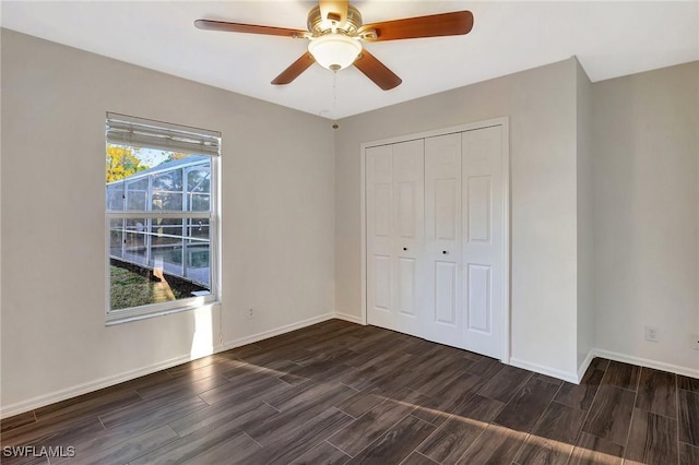 unfurnished bedroom with wood tiled floor, baseboards, and a closet