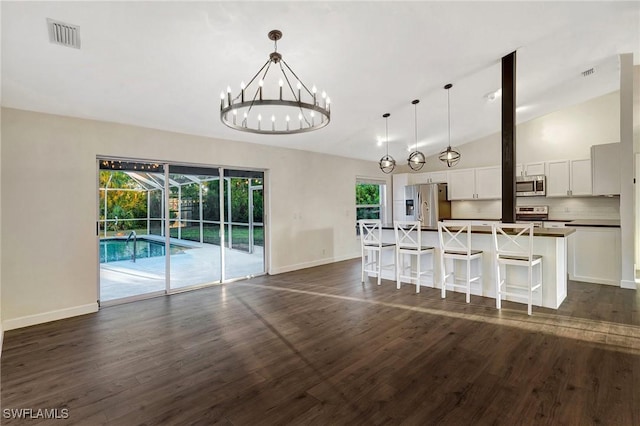 unfurnished dining area with visible vents, dark wood-style flooring, and a wealth of natural light