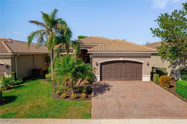 mediterranean / spanish-style house with a tiled roof, an attached garage, decorative driveway, a front yard, and stucco siding