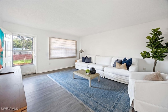 living room featuring dark wood-type flooring and baseboards