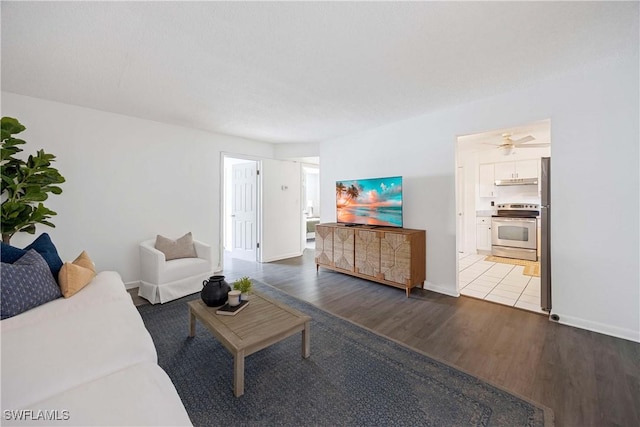 living area with baseboards and wood finished floors