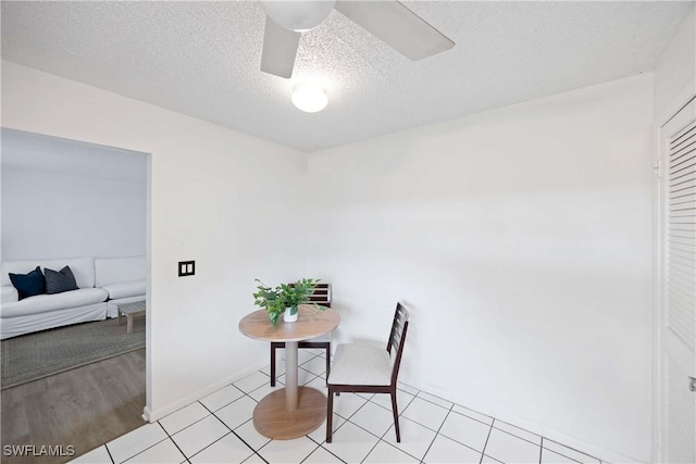 dining room with a textured ceiling, ceiling fan, and baseboards