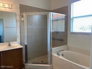 bathroom with a garden tub, a shower stall, and vanity